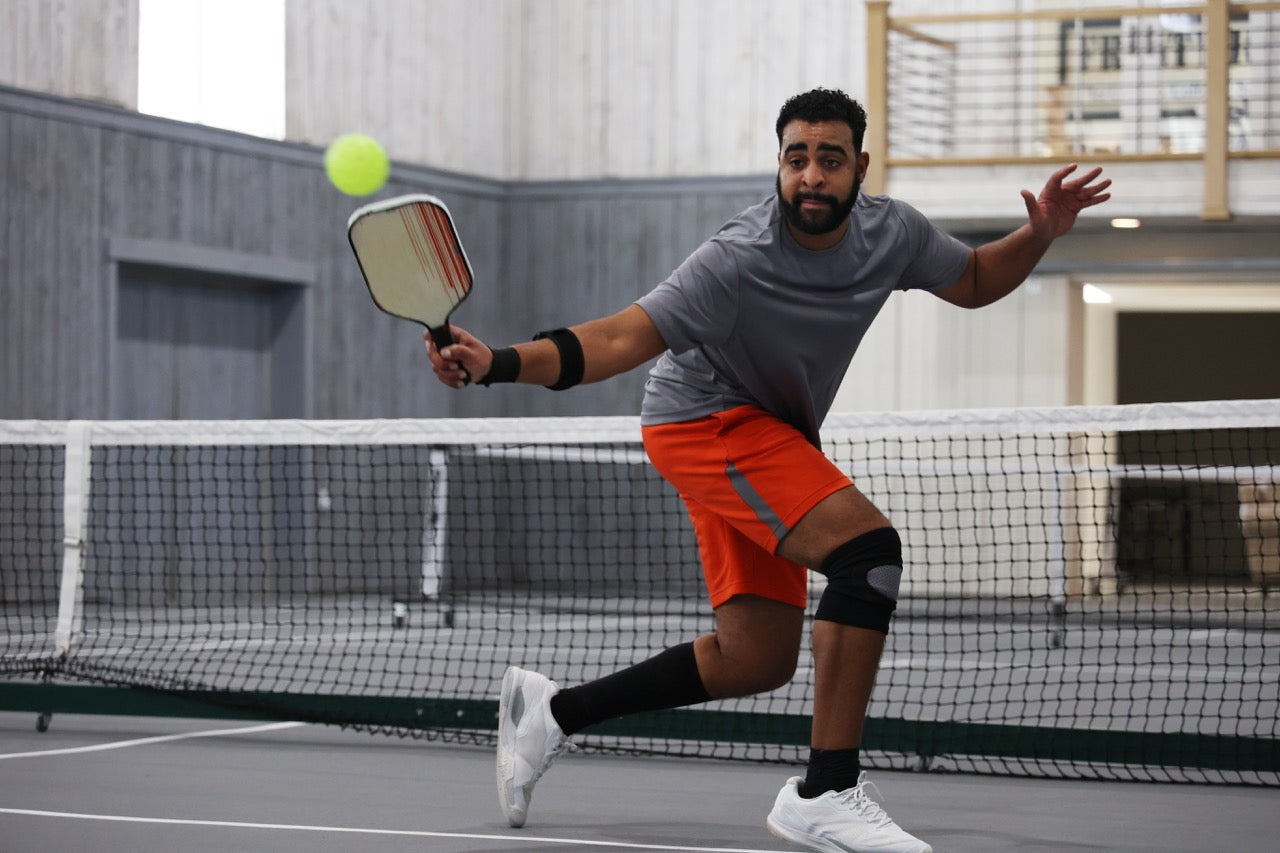 A man playing indoor singles pickleball 