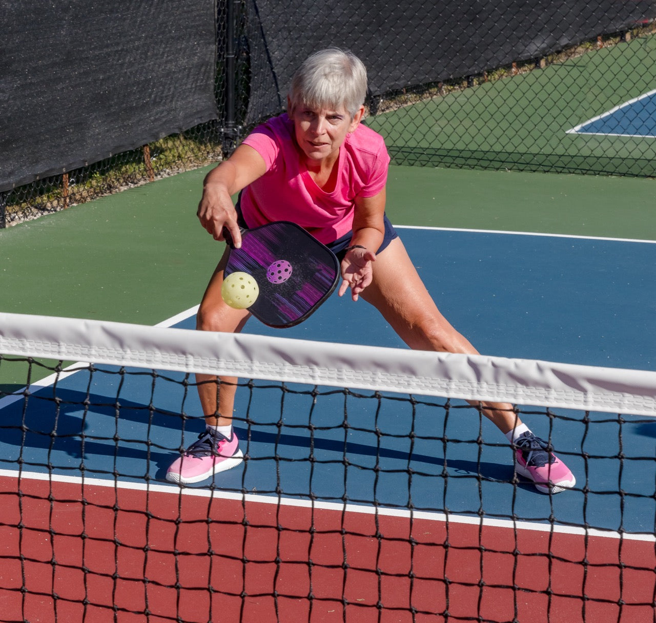 Woman playing pickleball with a portable pickleball net