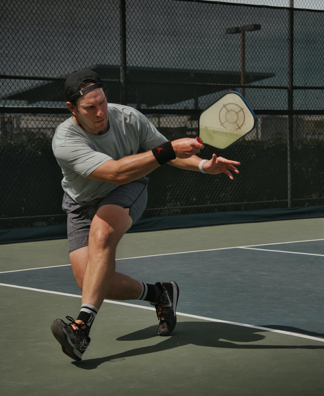 A man playing pickleball hitting a return from an opponents serve