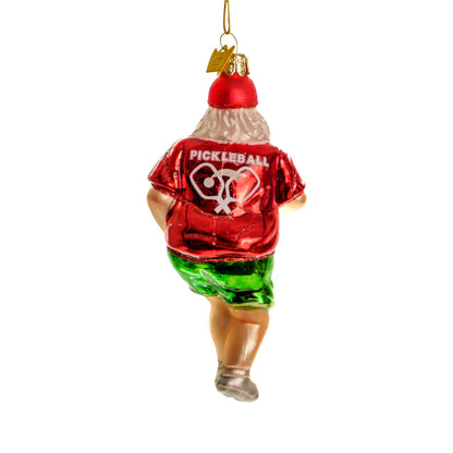 Back of a fun handmade glass Christmas ornament of Santa playing pickleball  hanging in front of a white studio backdrop