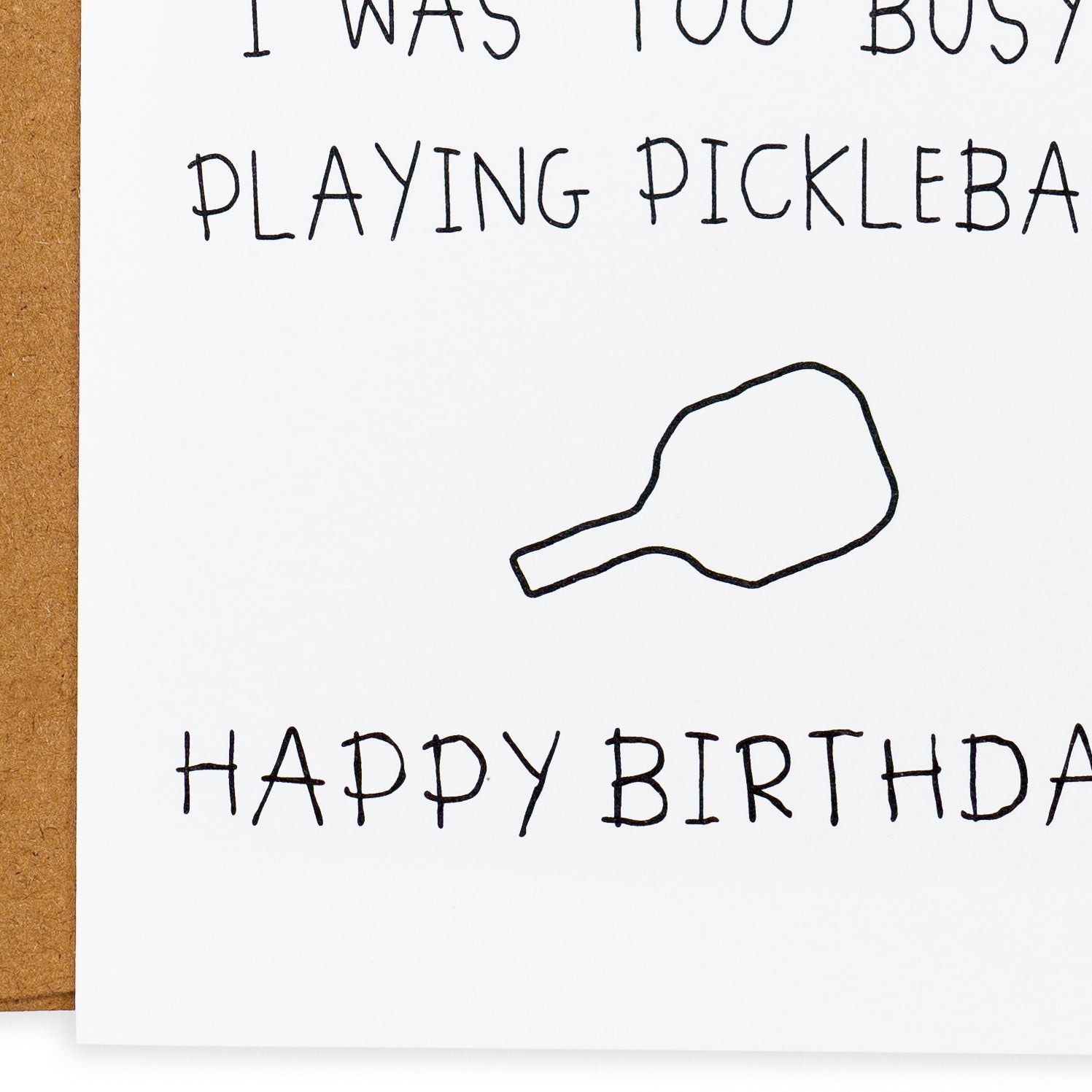 Close up of a funny pickleball birthday card that says &quot;I would have found a better card but I was too busy playing pickleball... Happy Birthday&quot; with a crudely drawn pickleball paddle