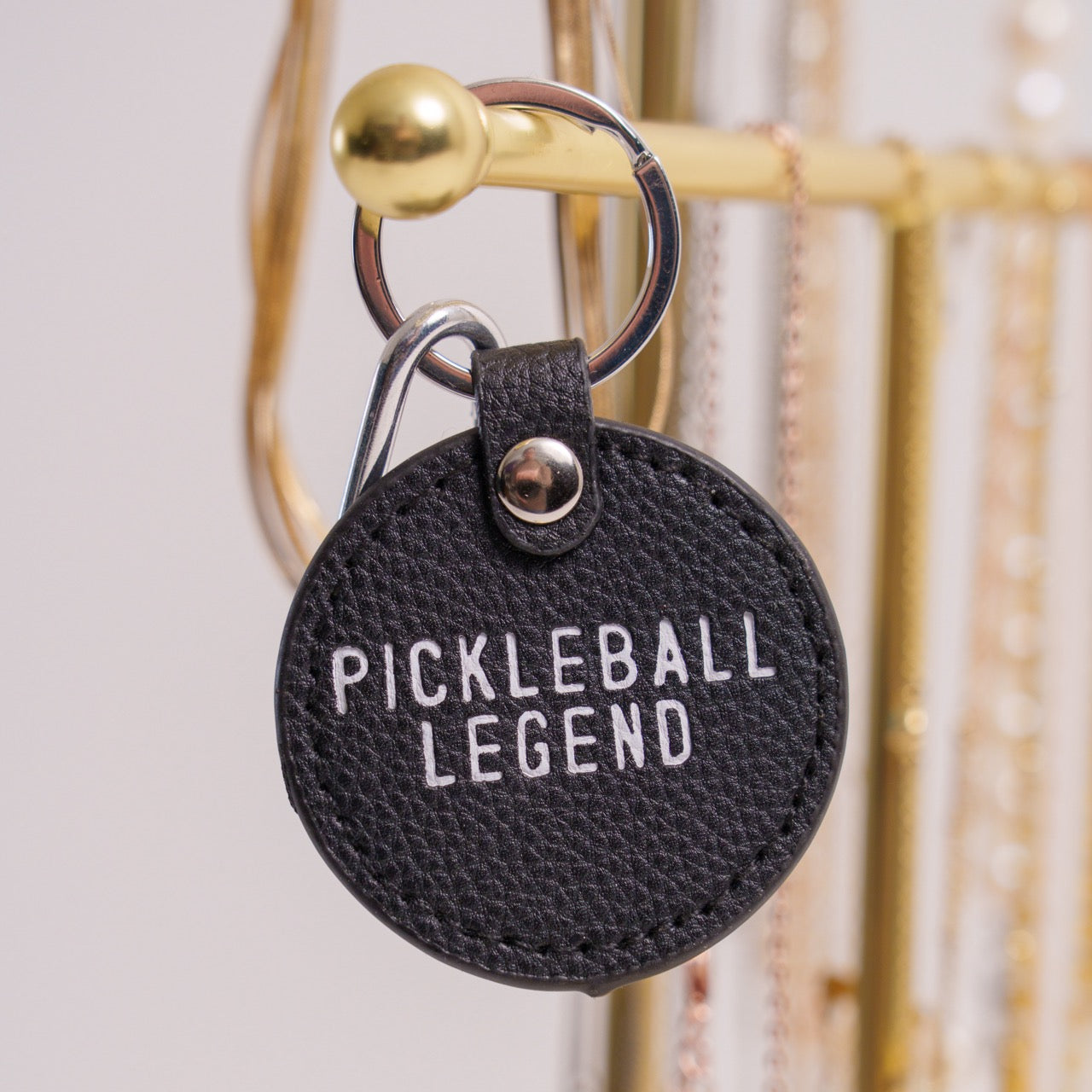 Black keychain that says Pickleball Legend on it hanging on jewelry holder