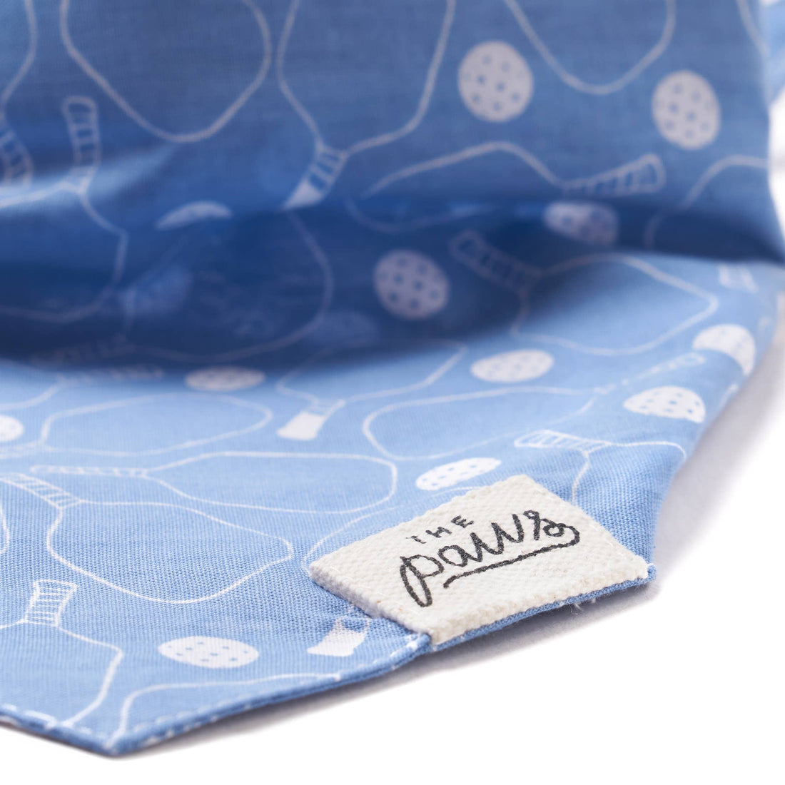 Detailed view of tag on blue pickleball-themed dog bandana