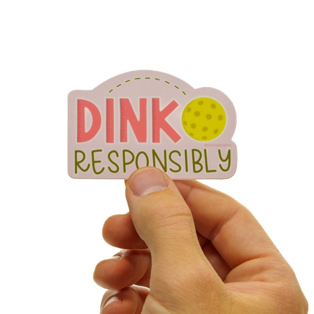 Dink Responsibly Sticker being held in front of studio back drop