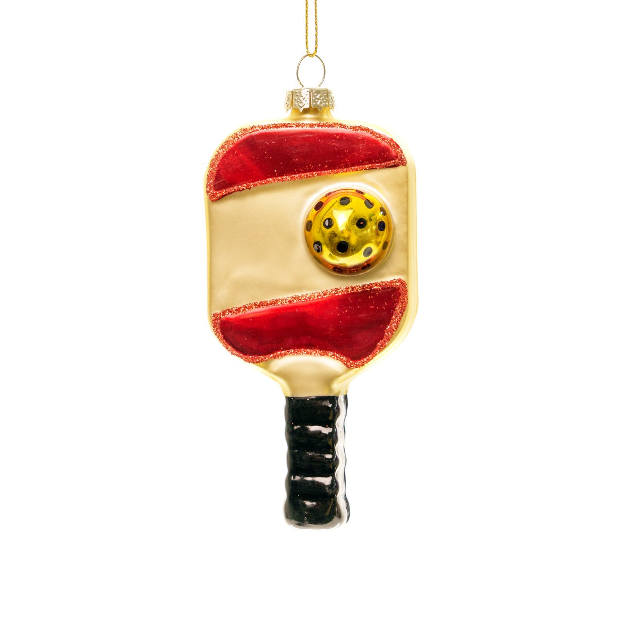 Front of a handmade glass red and gold pickleball paddle Christmas ornament hanging in front of a white studio backdrop