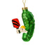 Left side of a fun handmade Kurt Adler Christmas ornament of a pickle holding a pickleball paddle and a pickleball on a white studio backdrop