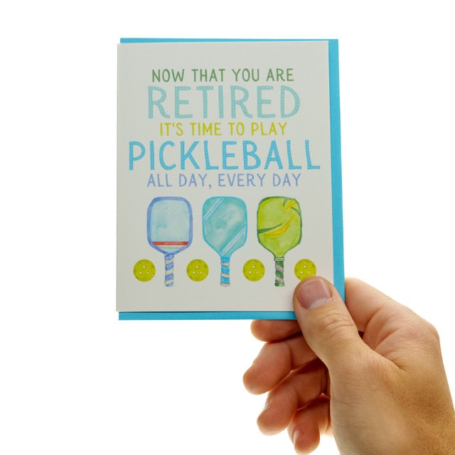 Pickleball retirement card with paddles and balls being held