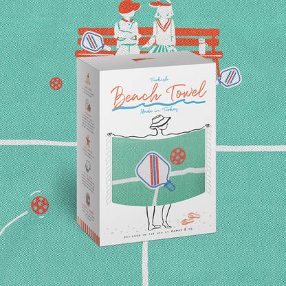 Front of packaging of Turkish pickleball themed beach towel with the beach towel in the background