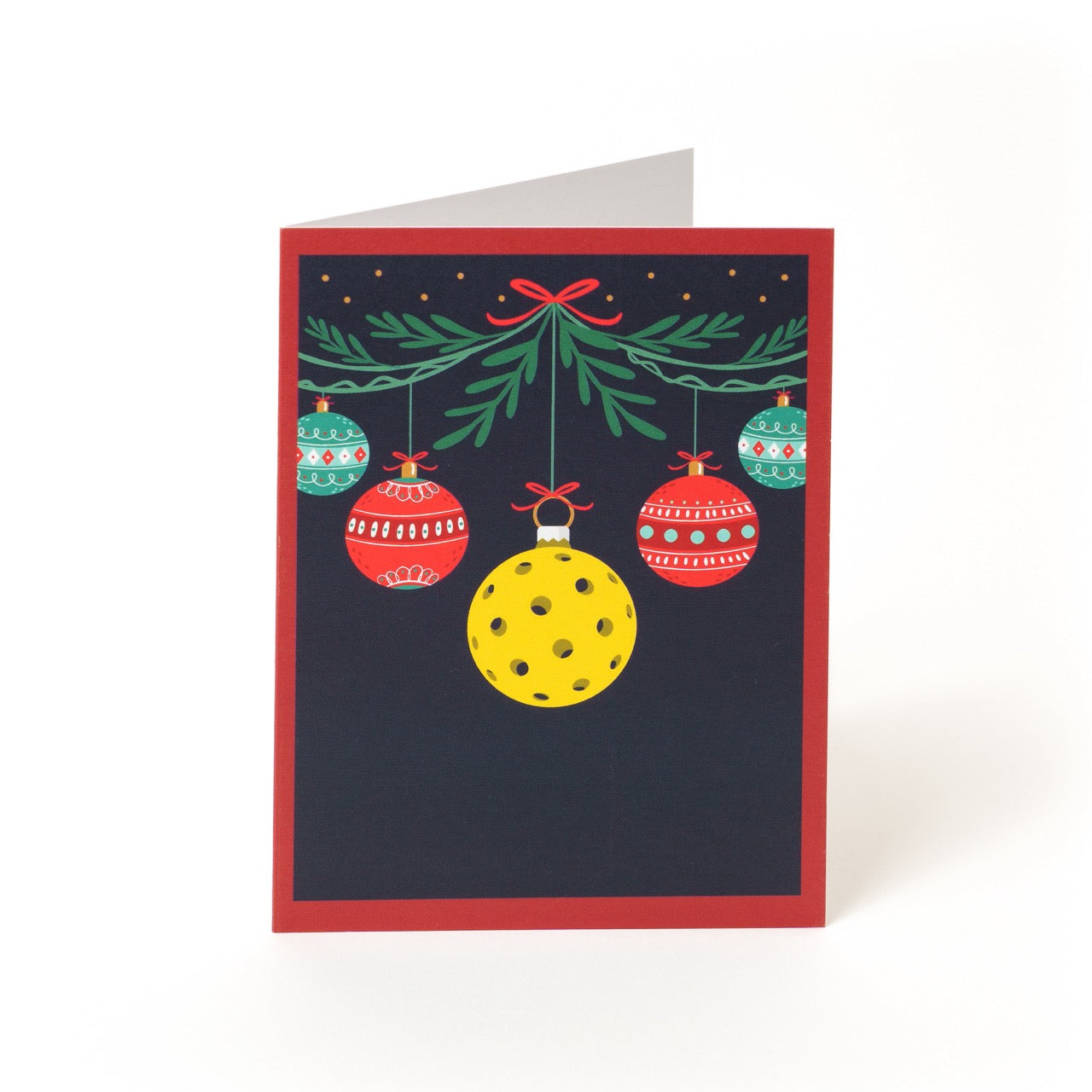 Pickleball themed Christmas greeting card with hanging ornaments with a message saying &quot;Merry Christmas and Happy New Year&quot; standing in front of a white studio backdrop