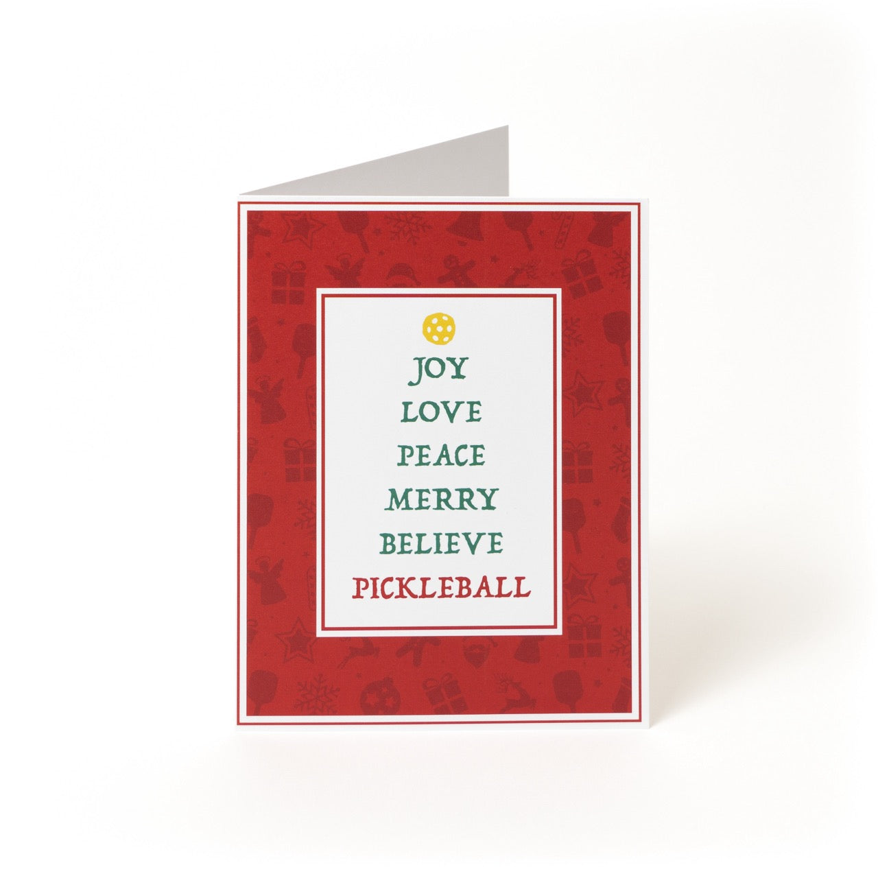 Pickleball themed greeting card with festive words stacked like a Christmas tree topped with a yellow pickleball standing on a white studio back drop