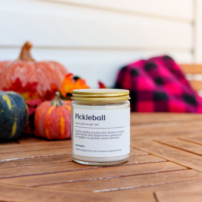 Pickleball definition candle on a table in front of pumpkins and a blanket