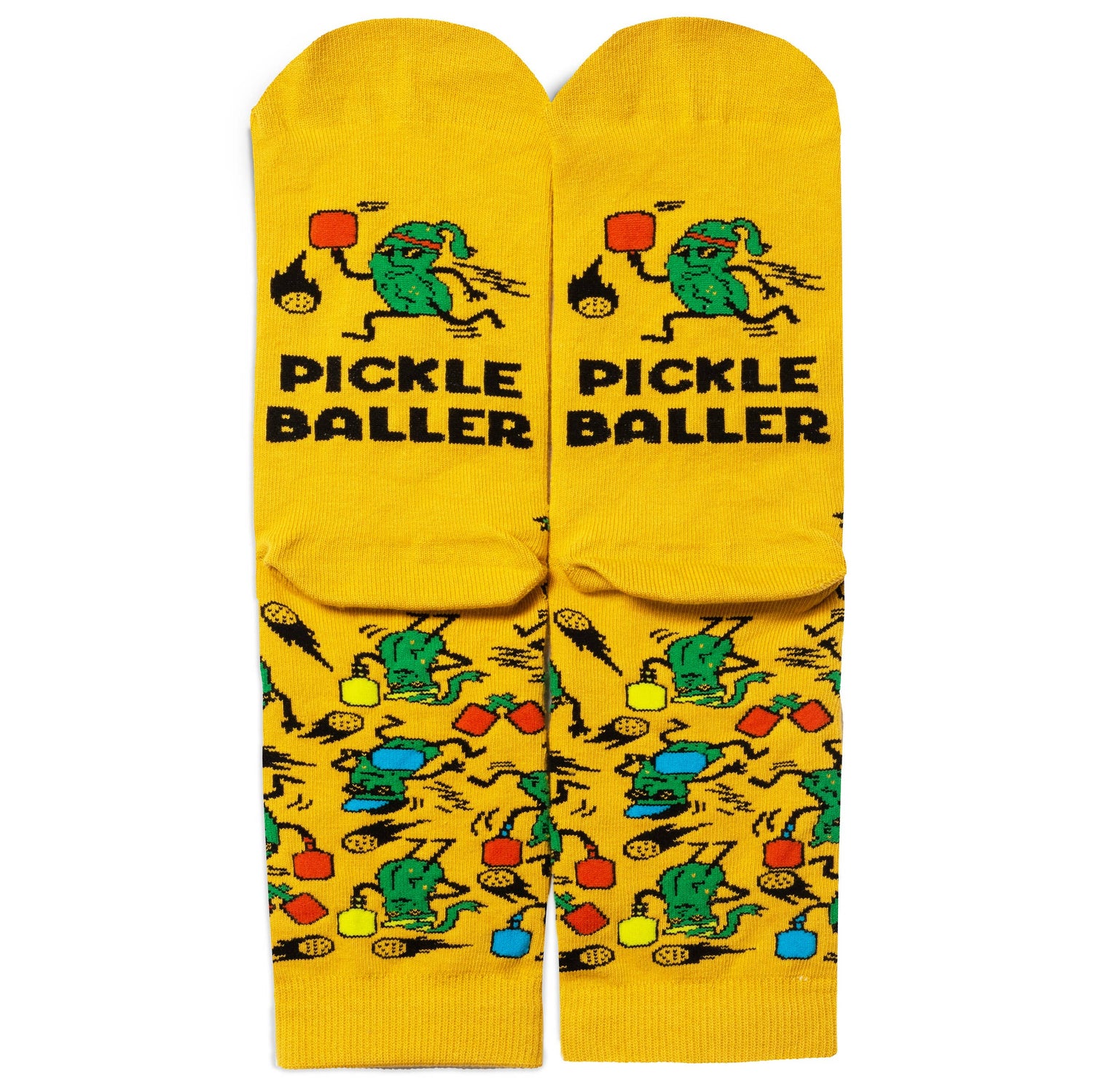 Soles of humorous yellow socks with pickles playing pickleball and say PICKLEBALLER on them