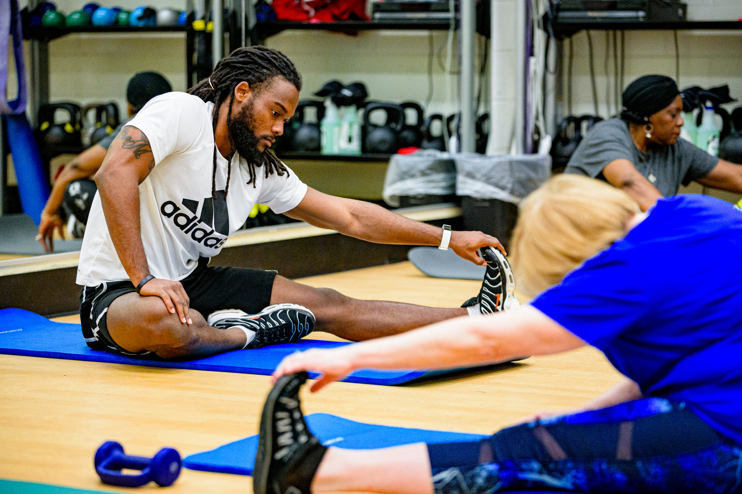 Man teaching a fitness class on how to prevent injuries in pickleball starting with stretches.