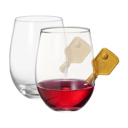 Angled view of stemless wine glasses with small metal pickleball paddles embedded into the glasses