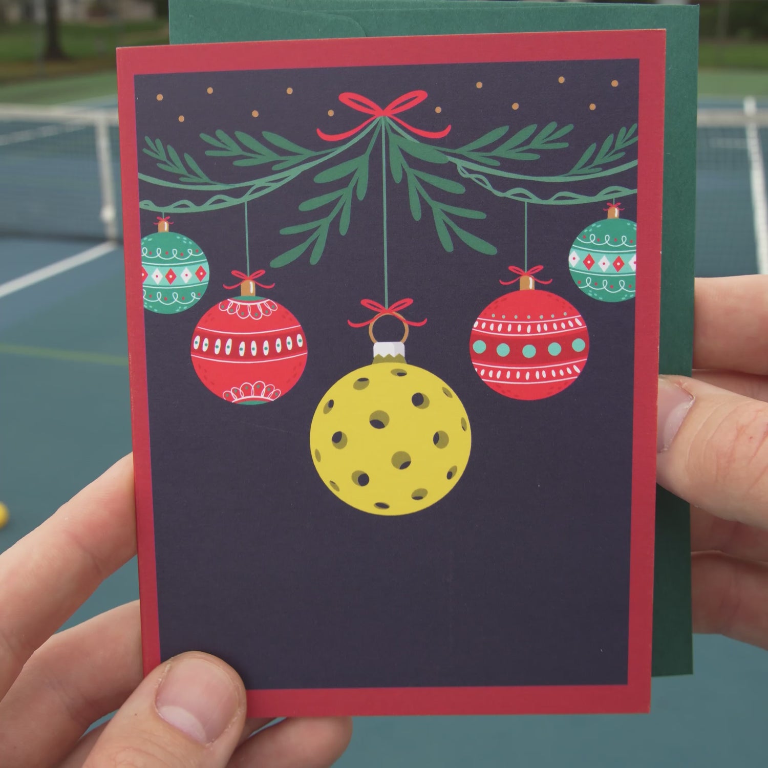 Video of a festive pickleball themed Christmas card featuring Christmas ornaments and a pickleball