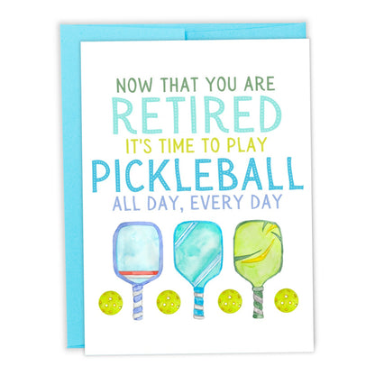 Pickleball-themed retirement card with pickleball paddles and balls on it laying flat