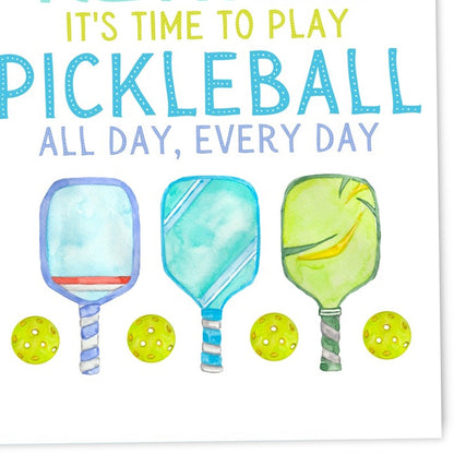 Close up of a pickleball-themed retirement card with pickleball paddles and balls on it laying flat