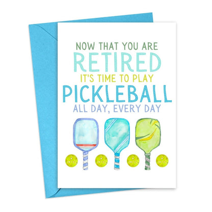 Pickleball-themed retirement card with pickleball paddles and balls on it laying flat