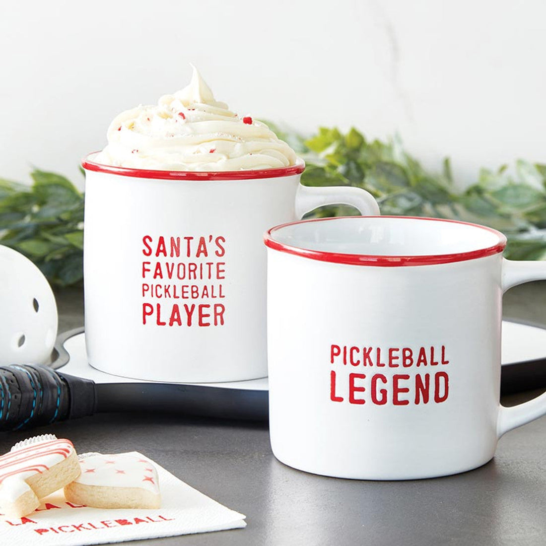 Two red and white ceramic mugs with pickleball themed sayings on them.